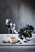 Blaue Trauben, Blauschimmelkäse und Rotwein auf Tisch