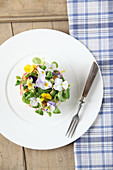 Potato salad spread with sour cream and edible flowers