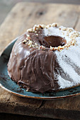 Nut cake with powdered sugar and chocolate glaze