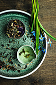 Herb tea leaves with scilla flowers on rustic background