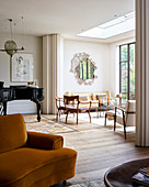 Klavier und Sessel mit gelbem Samtbezug im offenen Wohnbereich