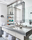 Metal frame and shelves on mirrored wall above washstand