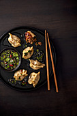 Dumplings mit Schweinefleischfüllung, Ingwer, Frühlingszwiebel und Sojasauce mit Koriandergrün