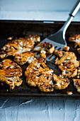 Spicy marinated, oven-baked cauliflower on a baking tray
