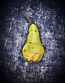 A pear on a grey metal surface