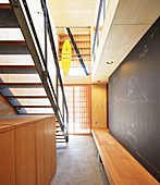 Custom wooden bench and chalkboard wall in stairwell