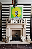 Eclectic collection of vases on mantelpiece below pop-art portrait of Marsha Hunt