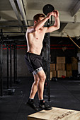 A young man performing explosive step-ups on a vaulting box