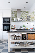 Open-sided island counter and chequered floor in bright kitchen