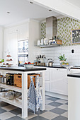 Open-sided island counter and chequered floor in L-shaped kitchen