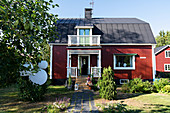 Rotes Schwedenhaus mit sommerlichem Vorgarten