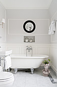 Free-standing bathtub in bathroom with panelled wainscoting