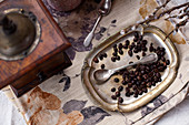 Vintage coffee grinder and metal plate with coffee beans and a spoon