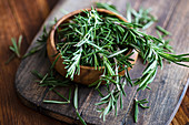 Organic fresh rosemary herb on textile napkin on wooden table