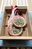 Slices of rabbit with a herb and bacon filling