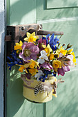 Colourful spring bouquet in felt cladding hung on door