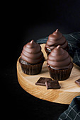 Chocolate cupcakes on wooden cutting board