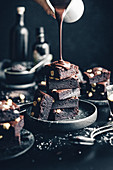 Schokoladen-Nuss-Brownies mit lauwarmer Schokolade übergiessen