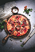 Herzhafte Pizza mit scharfer Salami auf Holzbrett