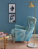 Mit Stoffmalfarbe bemalter Sessel in Wasserfarben-Optik vor blauer Wand