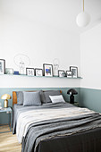 Bilderleiste an zweifarbiger Wand im Schlafzimmer mit klarer Linie