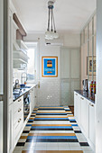 White cupboards, colourful tiled floor and subway tiles in kitchen