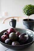 Aubergine, avocados and red onions in dark bowl