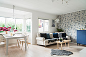 Heller Wohnraum mit Esstisch und Sofa im skandinavischen Stil