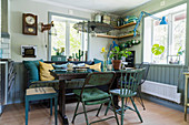 Dining table, wooden bench and various vintage chairs and stools in corner