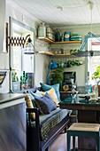 Wooden bench in seating corner of kitchen-dining room and kitchen utensils on L-shaped shelves