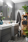 Twin washstands and accessories on wooden shelves in grey bathroom