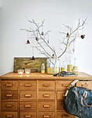 Gold-painted glass bottles on wooden chest of drawers