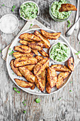 Spicy baked potatoe wedges served with guacamole