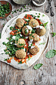 Falafel served on lavash with roasted tomatoes sauce, fresh parsley and garlic yoghurt sauce