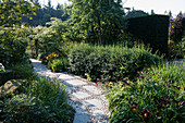 Paved garden path with slabs and pebbles between beds