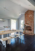 Table with benches and open fireplace in the rustic dining room