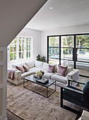 Glance into the living room with white sofa and window front to the garden
