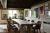 Long wooden dining table below mezzanine in renovated Antwerp house