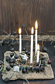 Kranz aus schwarzen Hagebutten mit vier Kerzen und Sternen aus Birkenrinde