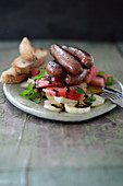 Merguez with a fiery melon and cucumber salad and a sesame seed baguette