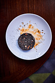 A slice of fried black sausage on a plate