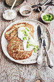 Potato cakes served with sour cream, black pepper and chopped green onions
