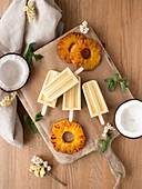 Slices of fresh pineapple, halves of ripe coconut with mint and delicious ice cream on board