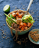 Soba noodle bowl with fried salmon, green asparagus and a sesame seed and lime dip