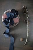 Wrapped gift decorated with black ribbon on pewter plate