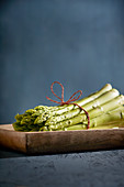 A bundle of green asparagus on a wooden dish