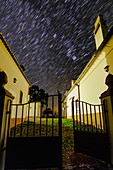 Star trails over Noudar Park buildings, time-exposure image