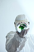 Scientist in protective clothing holding globe in his hand