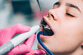 Orthodontist cleaning girl's braces