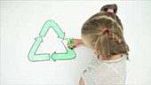 Girl colouring recycling symbol
